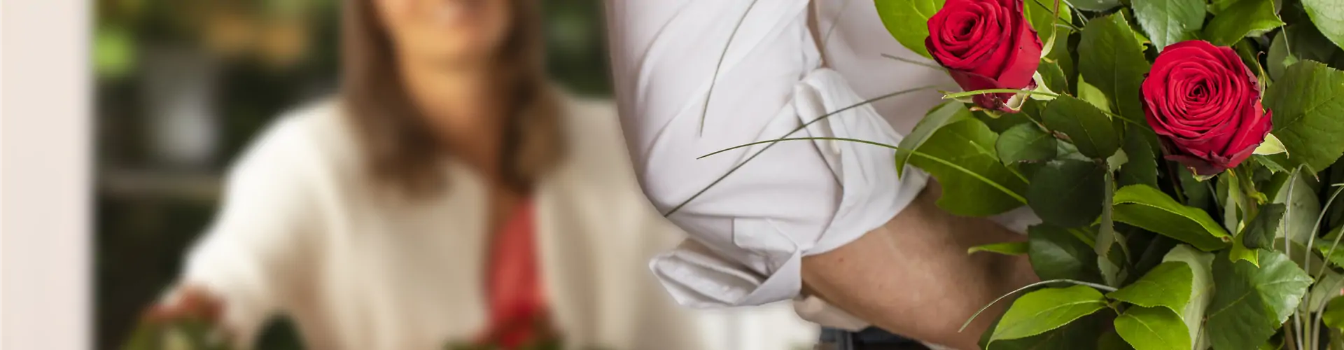 Mann überrascht Frau mit Strauß